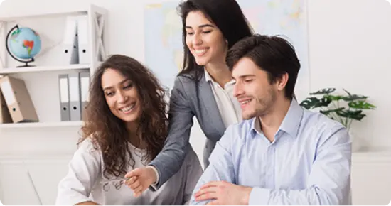 Happy couple booking travel at tourist agency